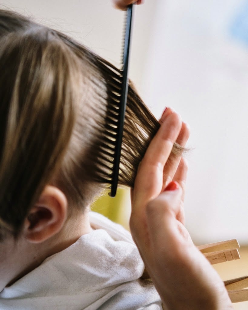 cutting a boy's hair with scissors