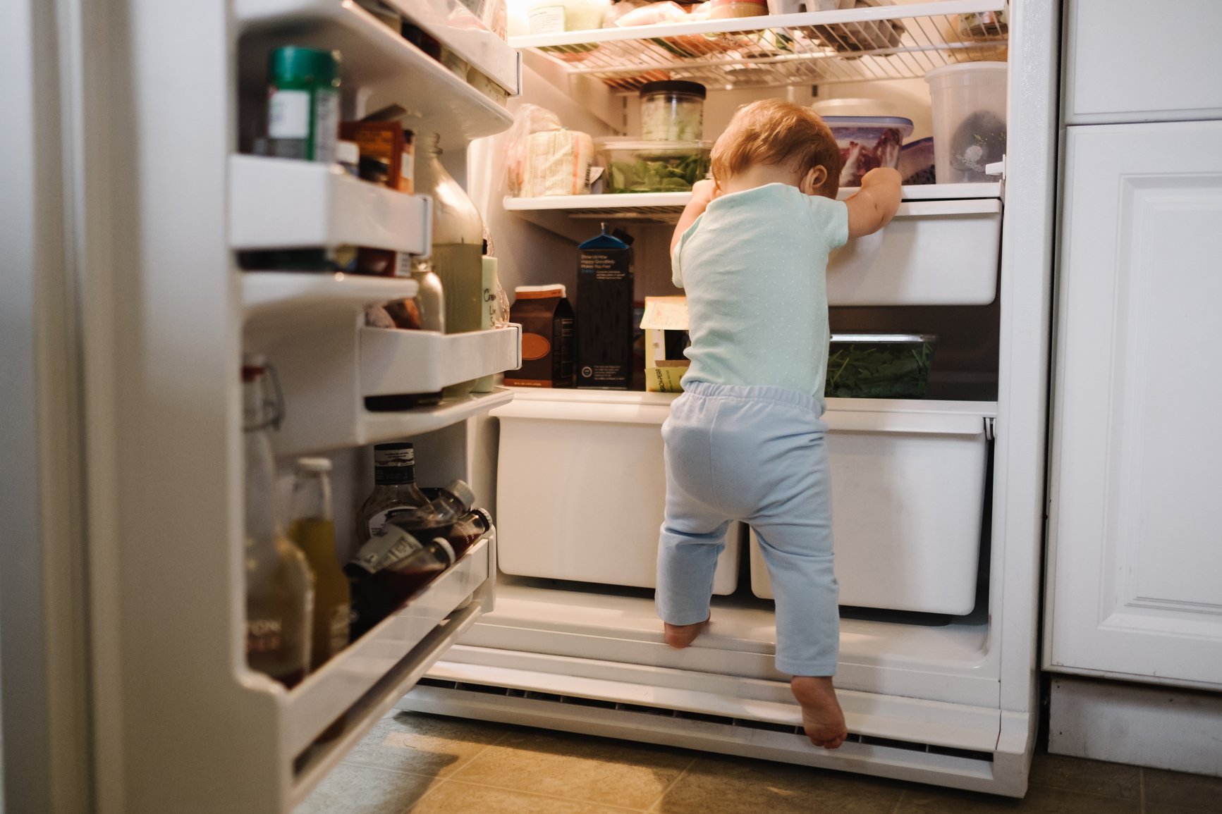 baby climbing on fridge